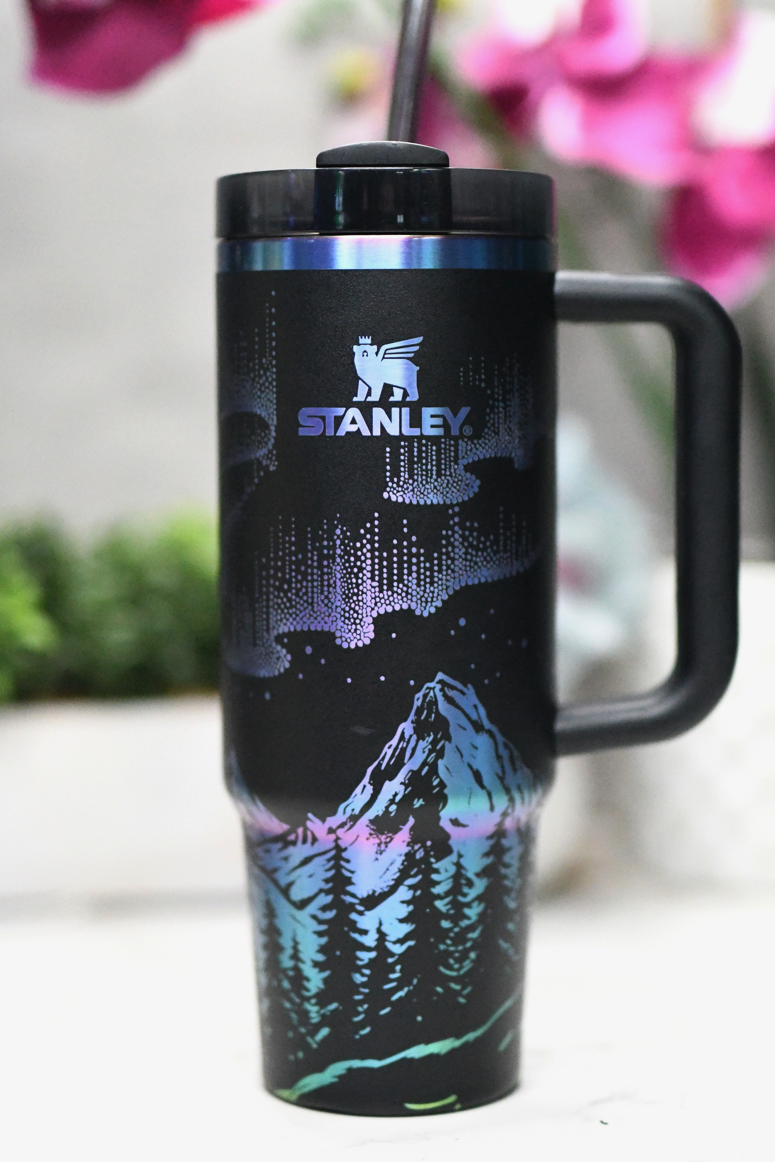 a black travel mug with a picture of a mountain on it