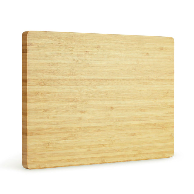 Bamboo cutting board standing at a slight angle against white.