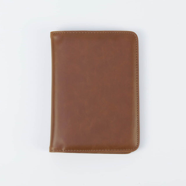 Brown passport wallet shown closed against white.