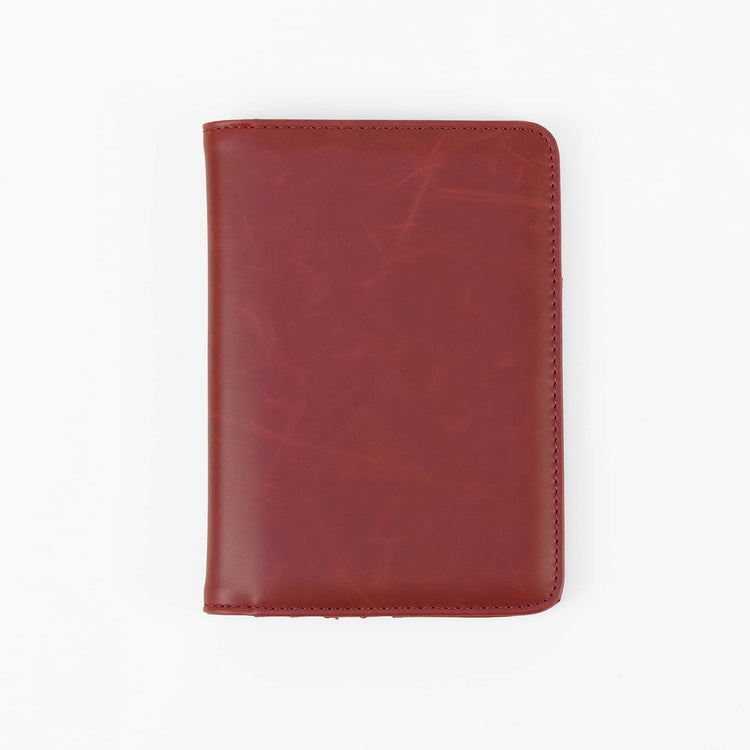 Red passport wallet shown closed against white.