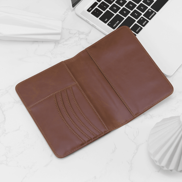 Brown passport wallet open to show card slots and passport pocket.