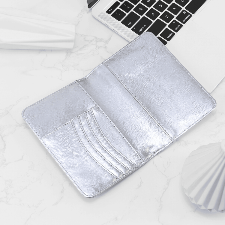 Silver passport wallet open to show card slots and passport pocket.
