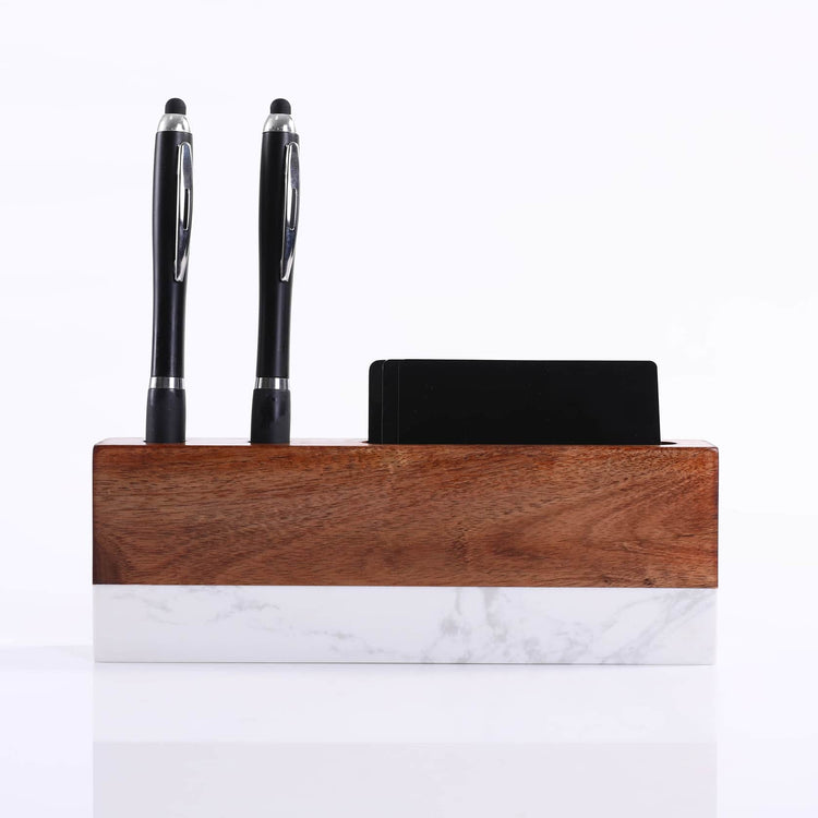 Desk organizer holding two black pens and a business card.
