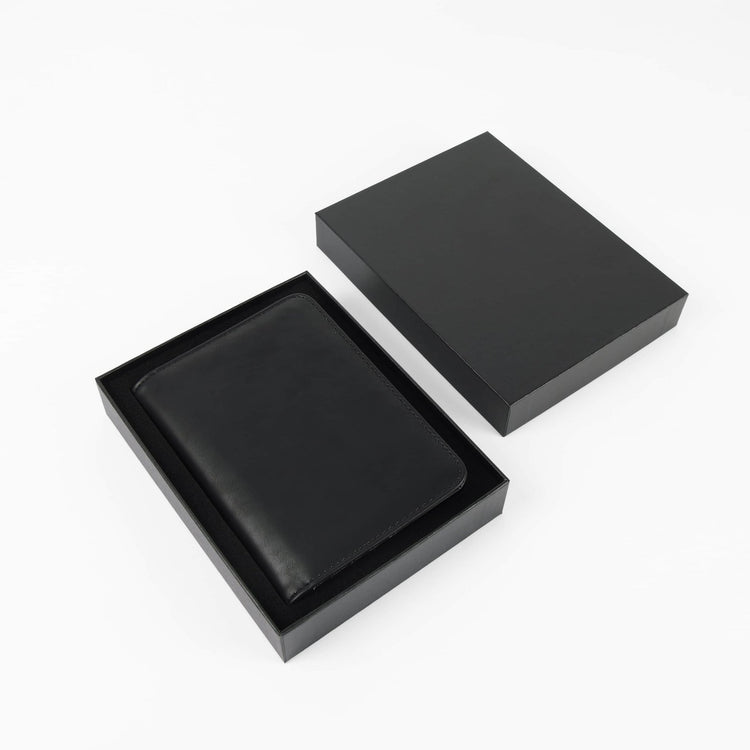 Black passport wallet displayed inside an open presentation box.
