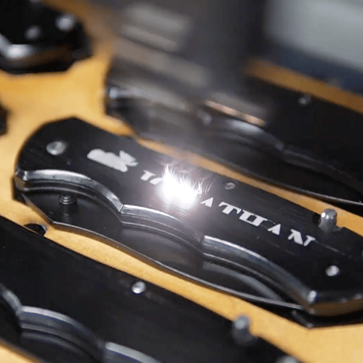 Pocket Knives — Metal Pocket Knife Being Engraved