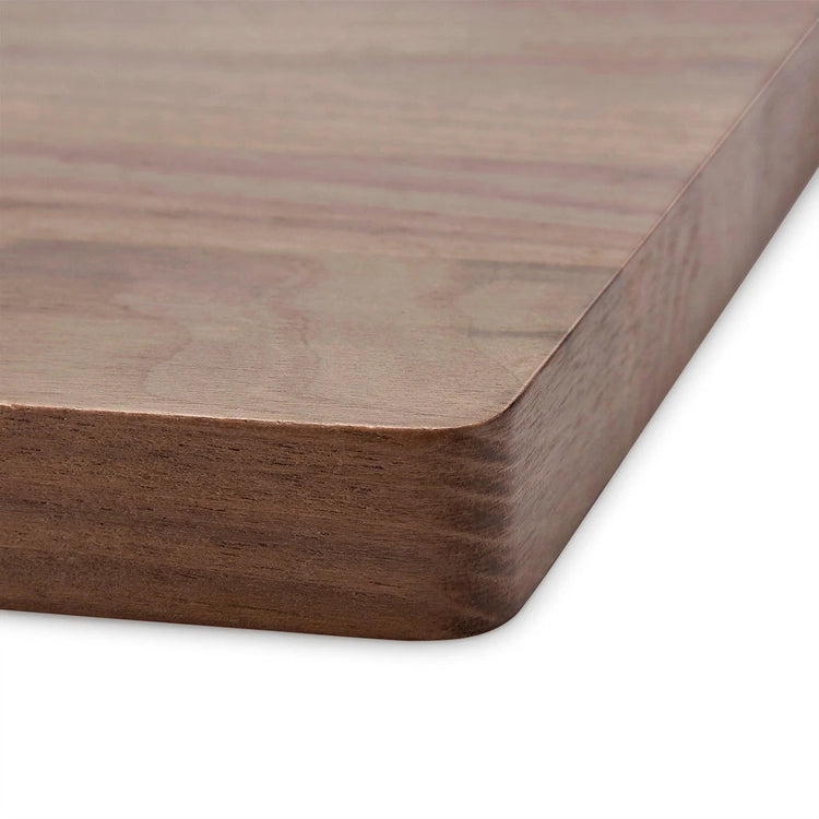 Close-up of the walnut board’s rounded corner and smooth edge.