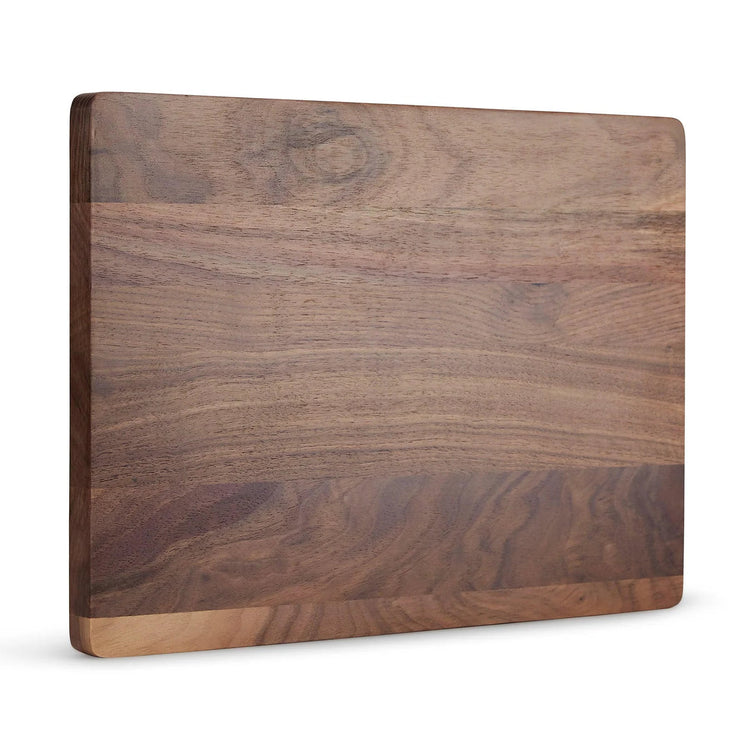 Full walnut cutting board standing upright against white.