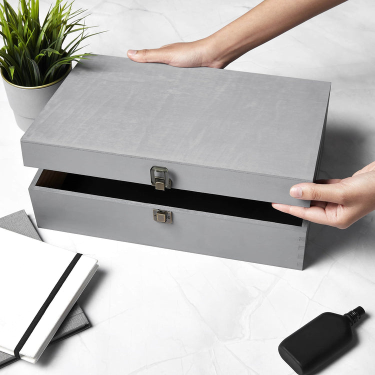 Gray memory box being opened to reveal black felt lining.