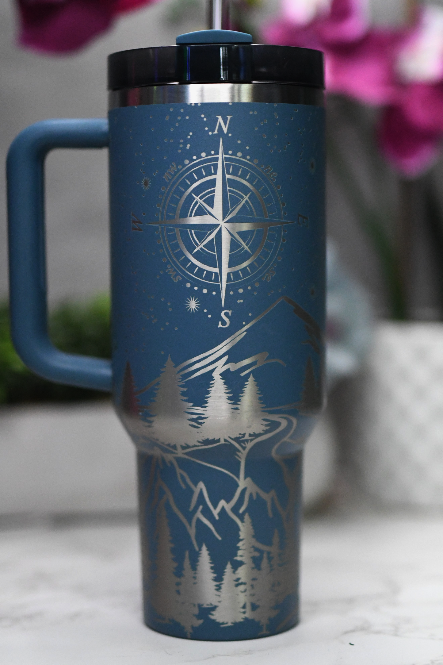 a blue travel mug with a compass on it