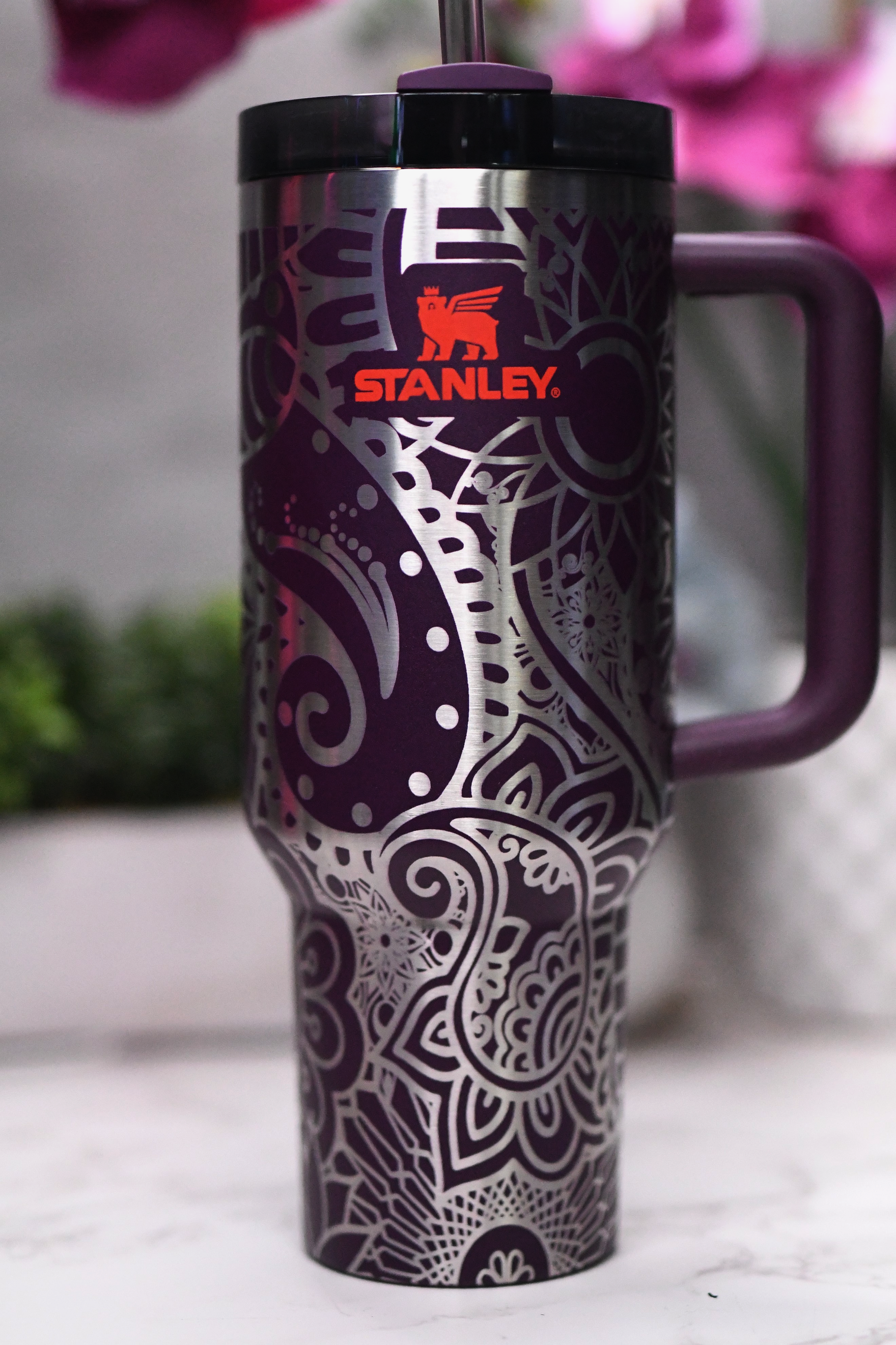 a purple travel mug sitting on top of a counter