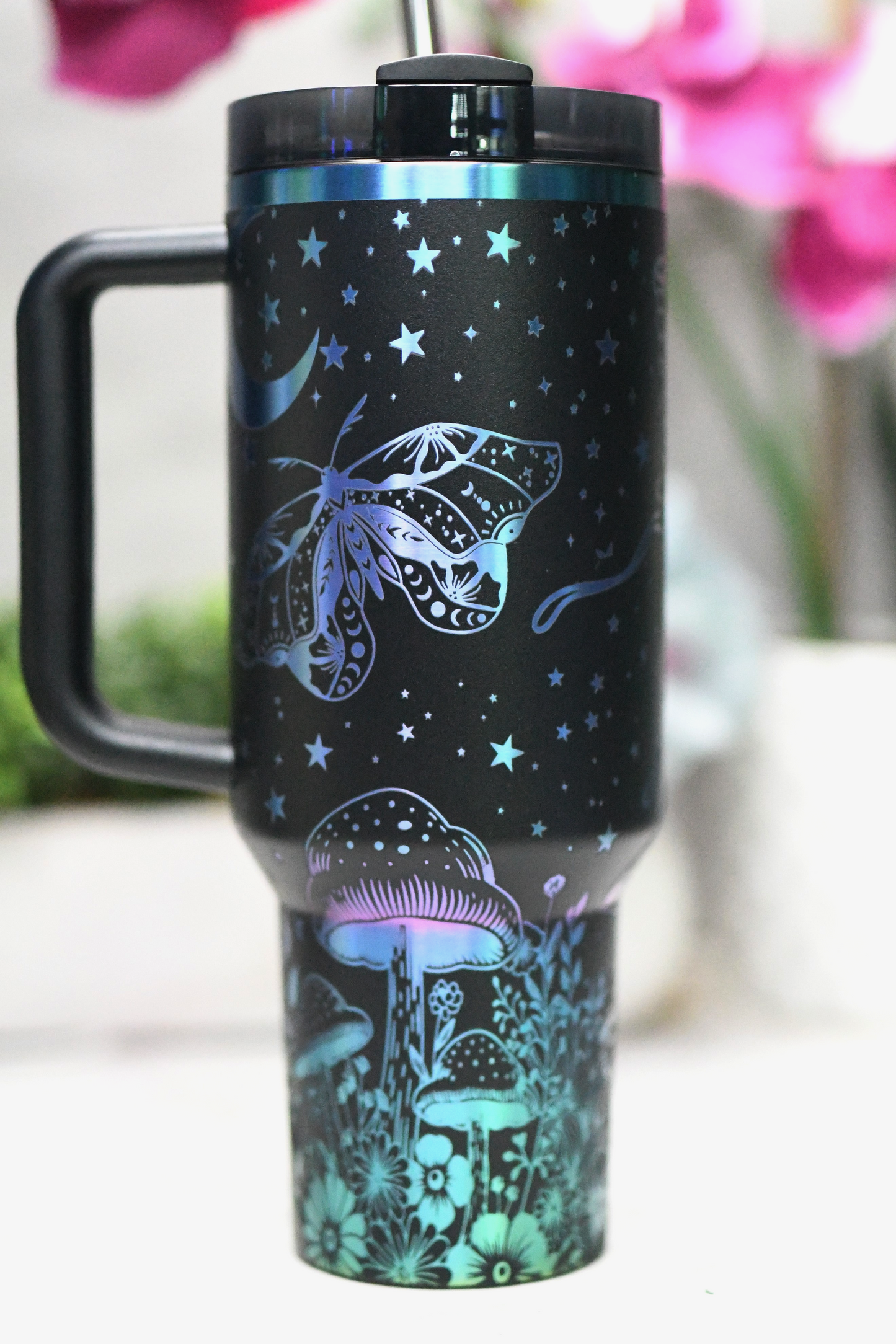 a travel mug with a butterfly design on it