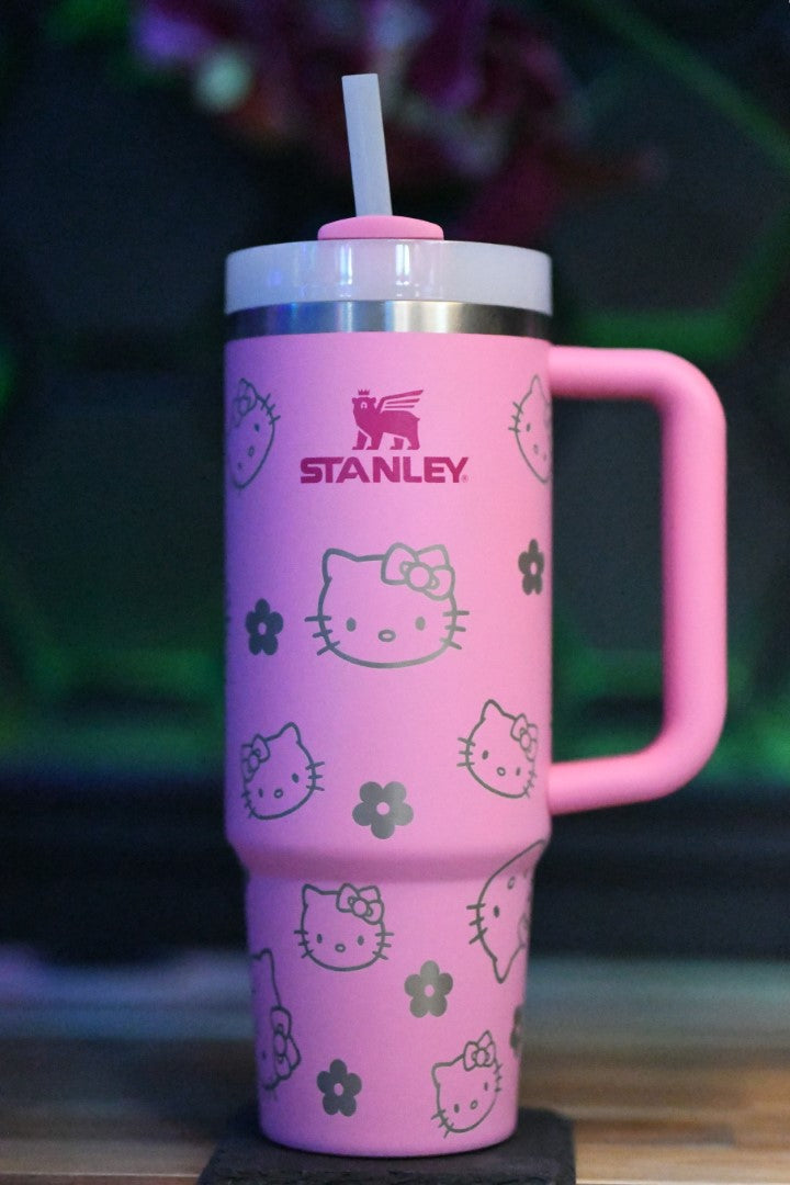 a pink cup with a hello kitty design on it