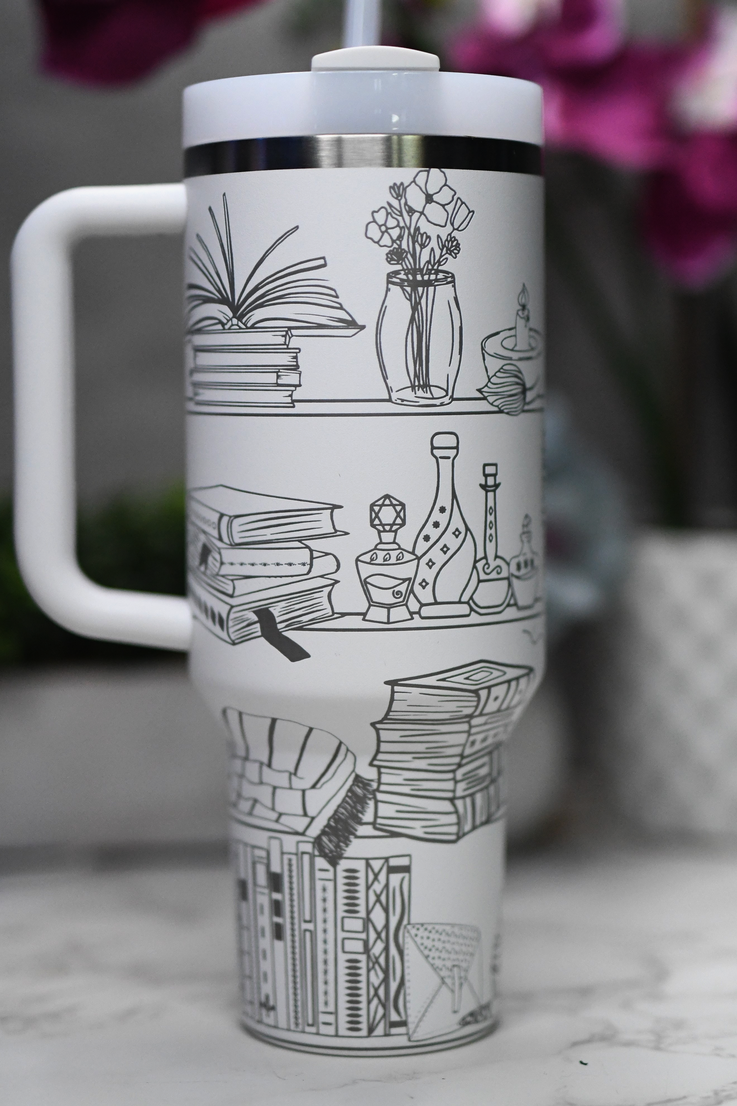 a white coffee cup with a drawing of books on it