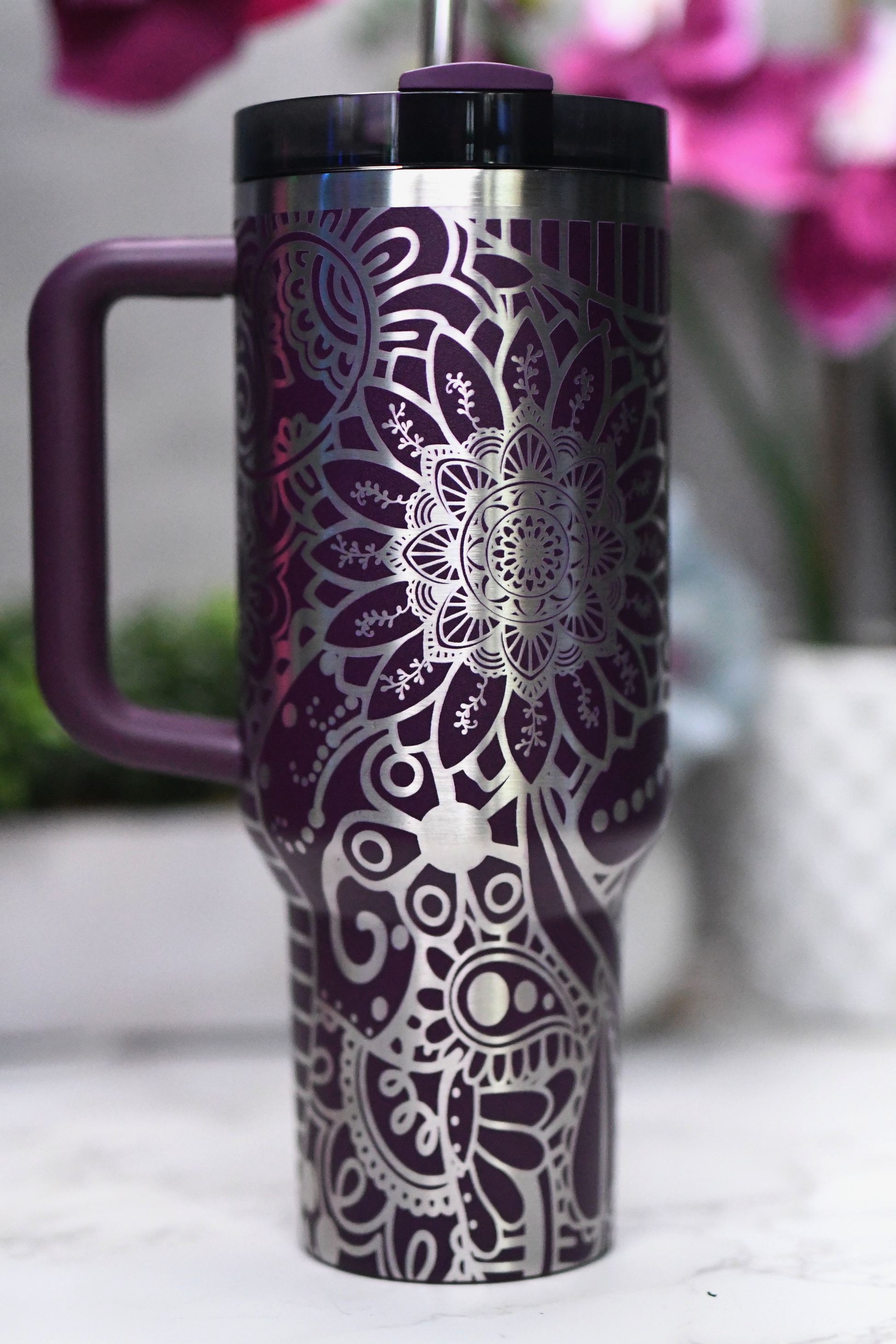 a purple and silver coffee cup sitting on top of a table