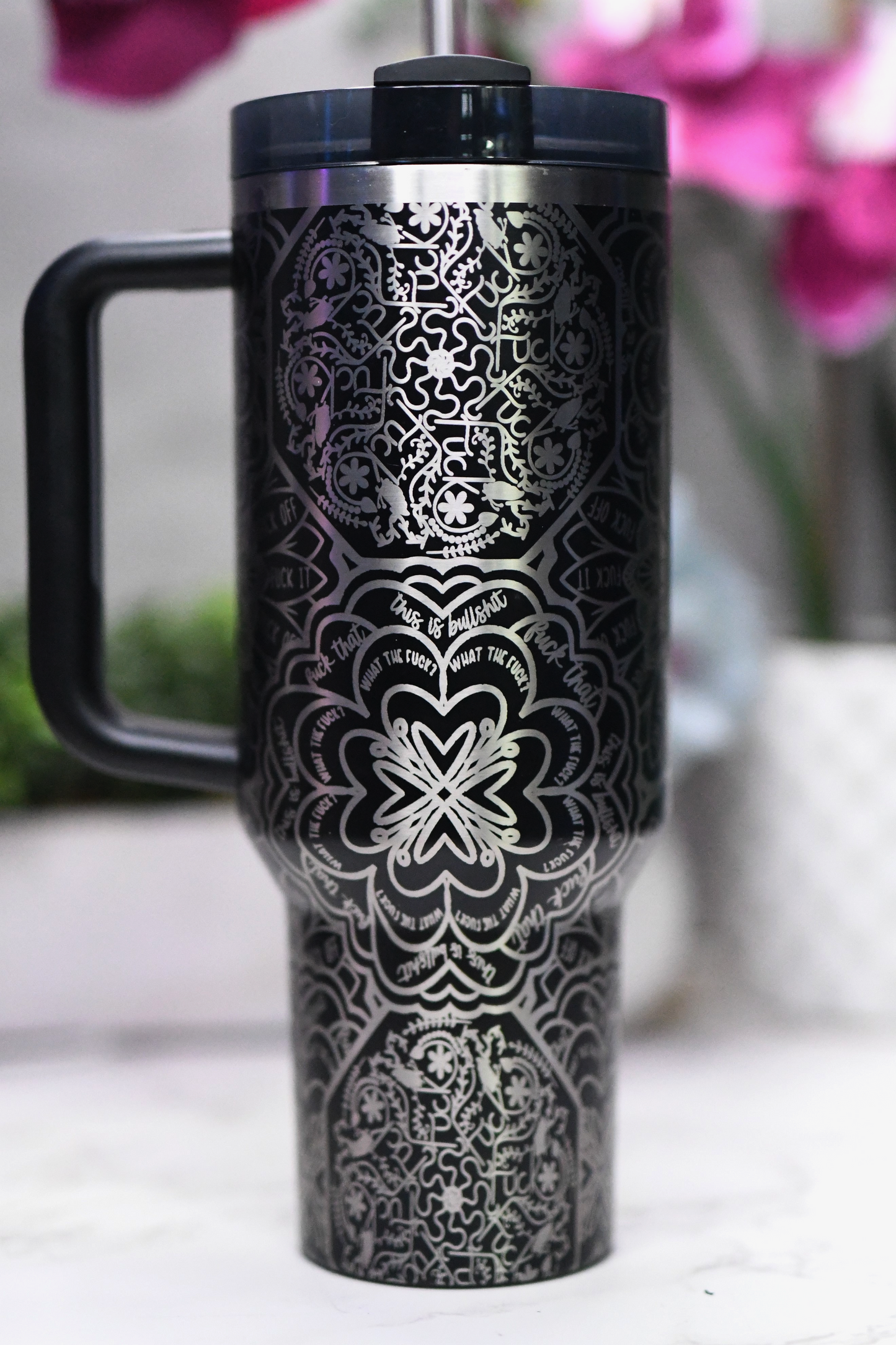 a black and silver travel mug sitting on a table