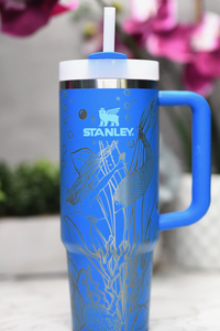 a blue travel mug with a straw sticking out of it