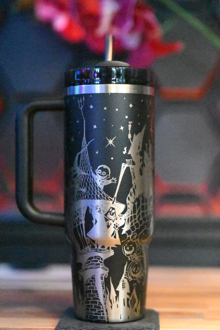 a black and silver travel mug sitting on top of a wooden table