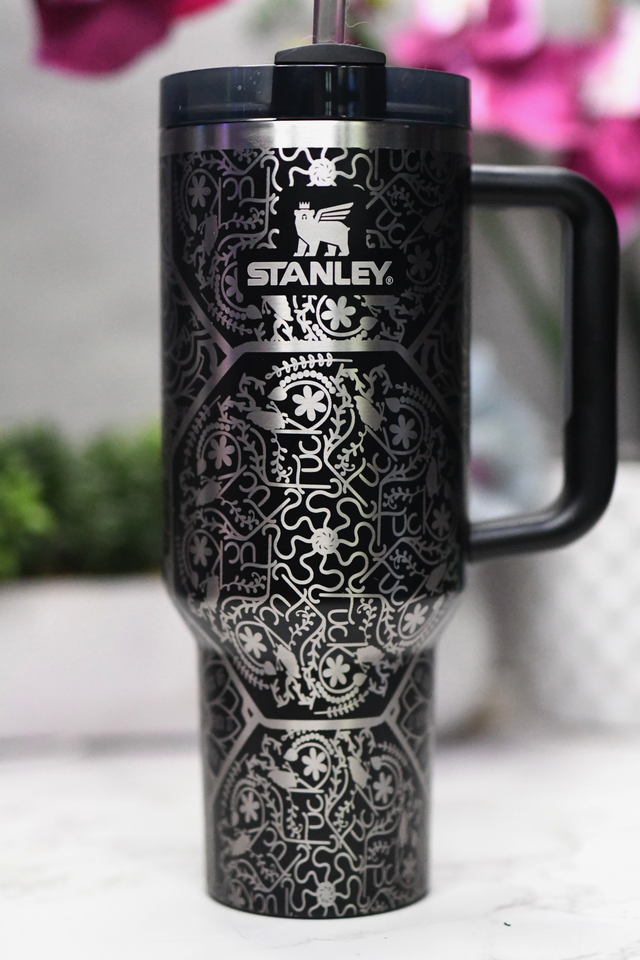 a black and white travel mug sitting on a counter