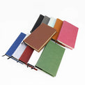 Twelve-color assortment of closed journal notebooks.