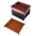 Assorted valet tray colors stacked with one rawhide tray assembled.