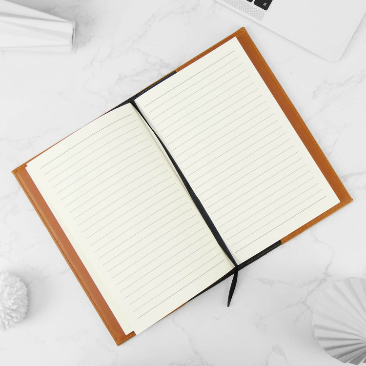 Rawhide journal notebook open to its lined cream pages.