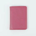 Pink passport wallet shown closed against white.
