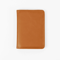 Rawhide passport wallet shown closed against white.