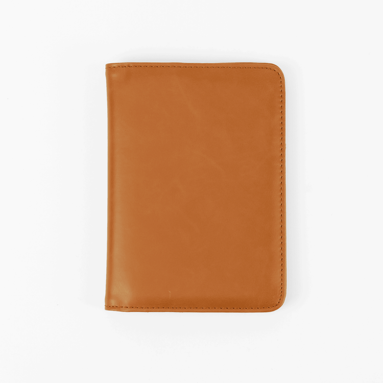 Rawhide passport wallet shown closed against white.