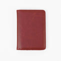 Red passport wallet shown closed against white.