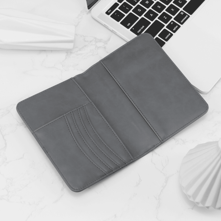 Gray passport wallet open to show card slots and passport pocket.