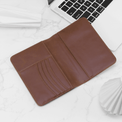 Brown passport wallet open to show card slots and passport pocket.