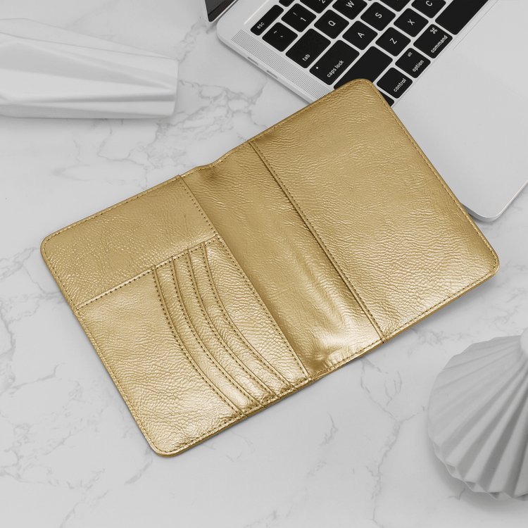 Gold passport wallet open to show card slots and passport pocket.