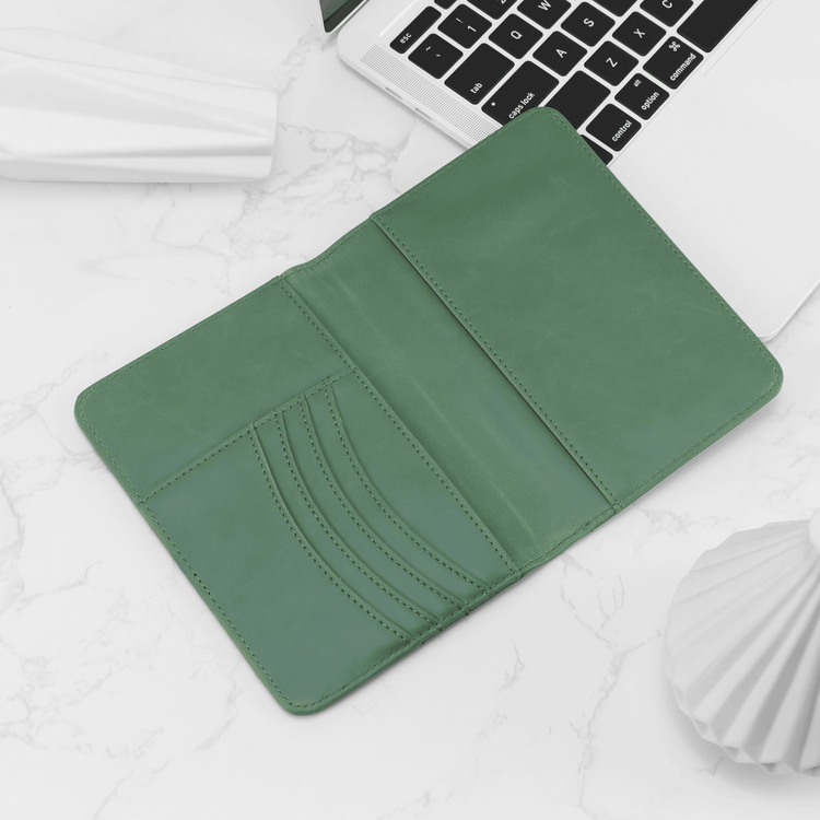 Sage green passport wallet open to show the curved card slots.