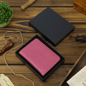 Pink passport wallet displayed inside an open presentation box.