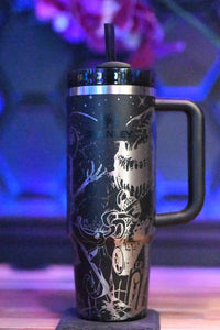 a black and silver coffee cup sitting on top of a wooden table