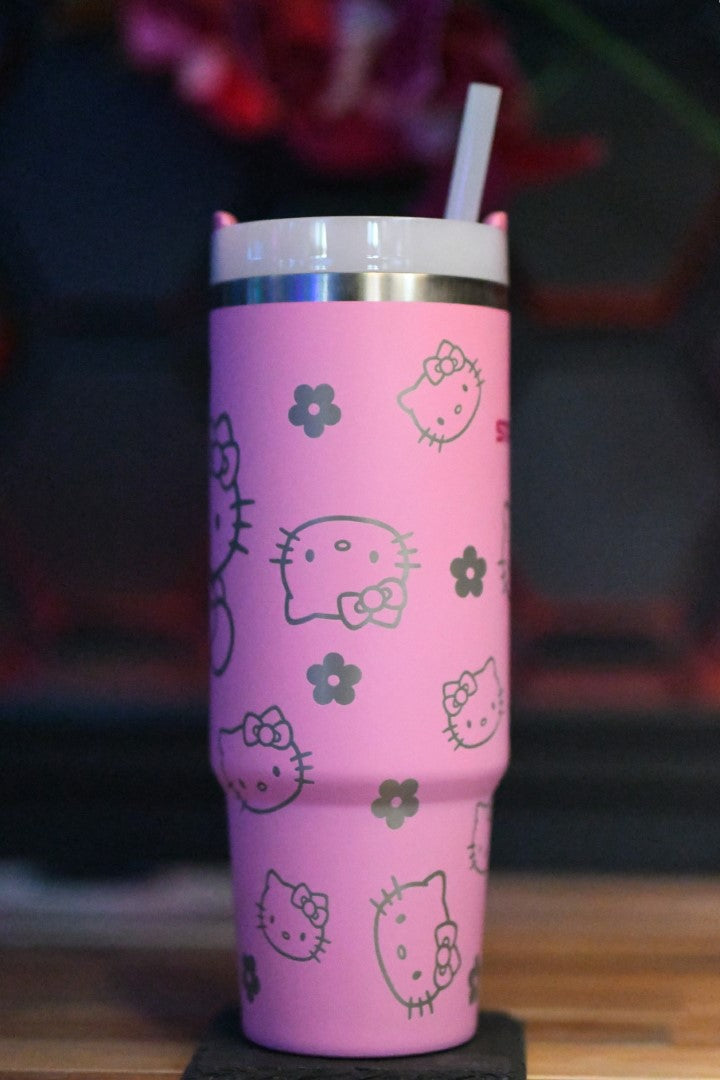 a pink hello kitty cup with a straw in it