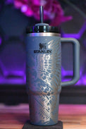 a stainless steel travel mug sitting on a wooden table