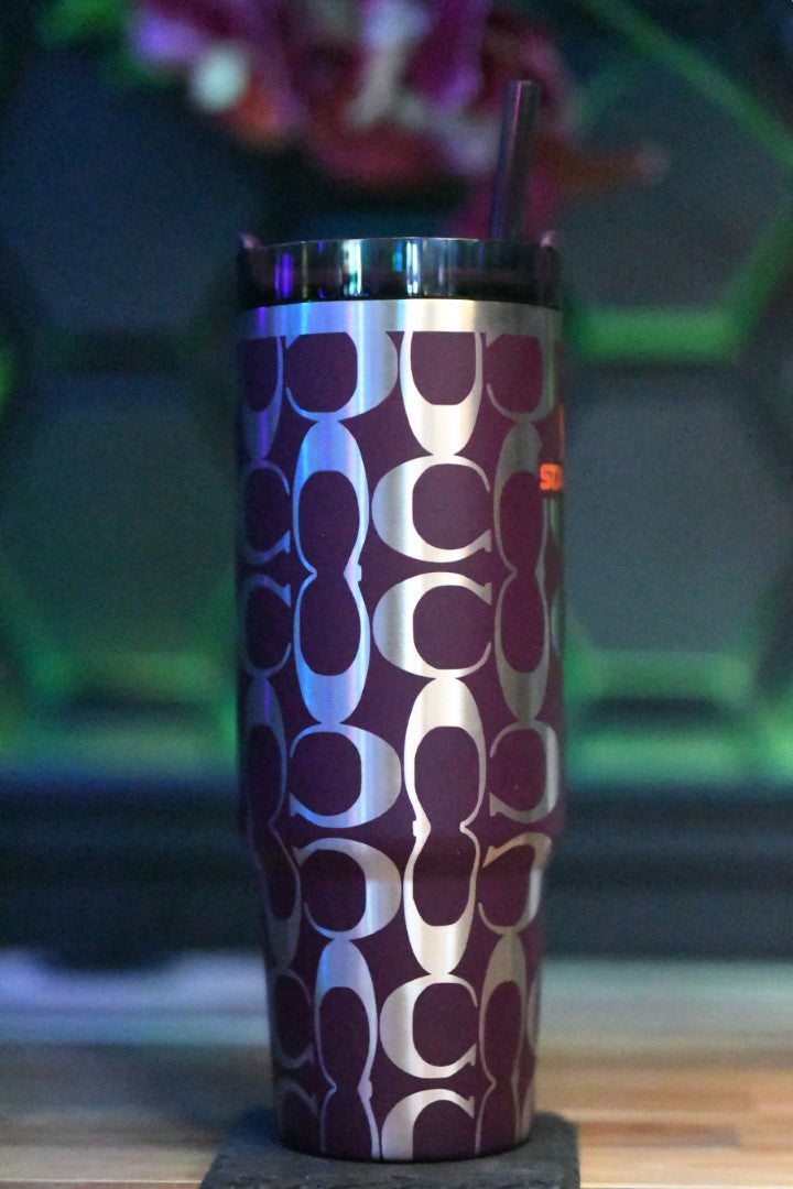 a purple and white cup sitting on top of a wooden table