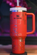 a red travel mug with a straw in it