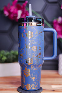 a blue and gold travel mug sitting on a table