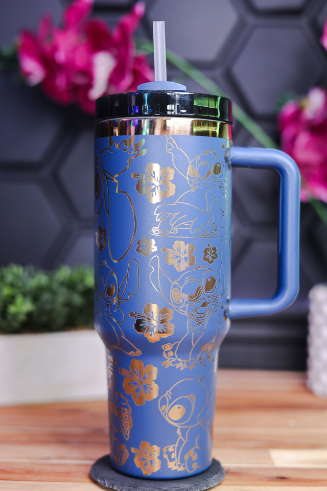 a blue and gold travel mug sitting on a table