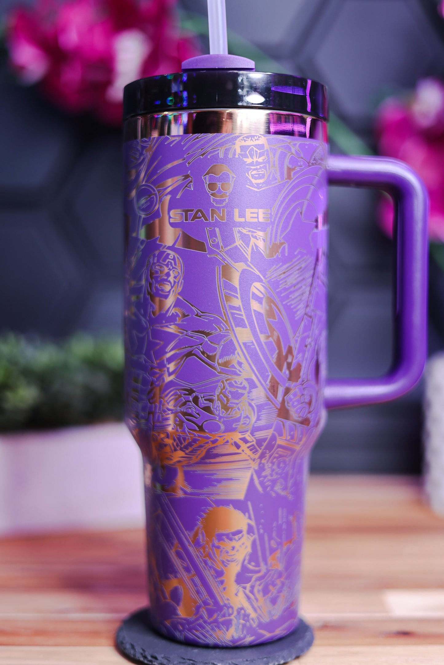 a purple and gold travel mug sitting on top of a wooden table