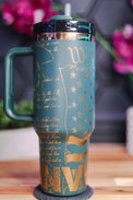 a blue and gold travel mug sitting on top of a wooden table