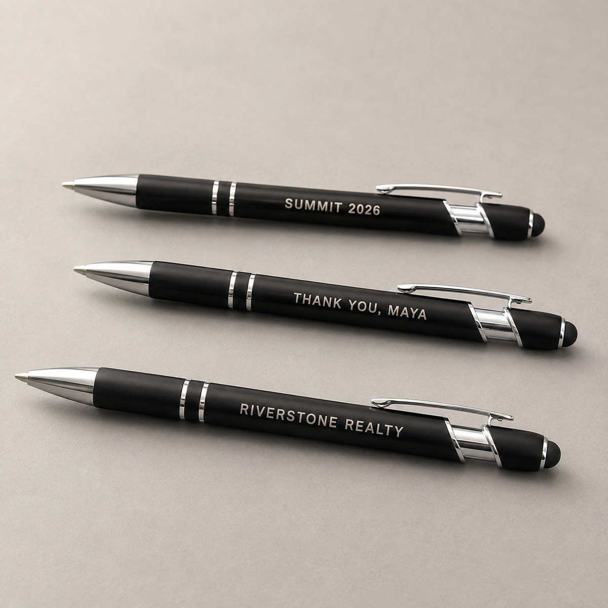 Three black personalized metal pens engraved for a business, customer gift, and event