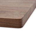 Close-up of the walnut board’s rounded corner and smooth edge.
