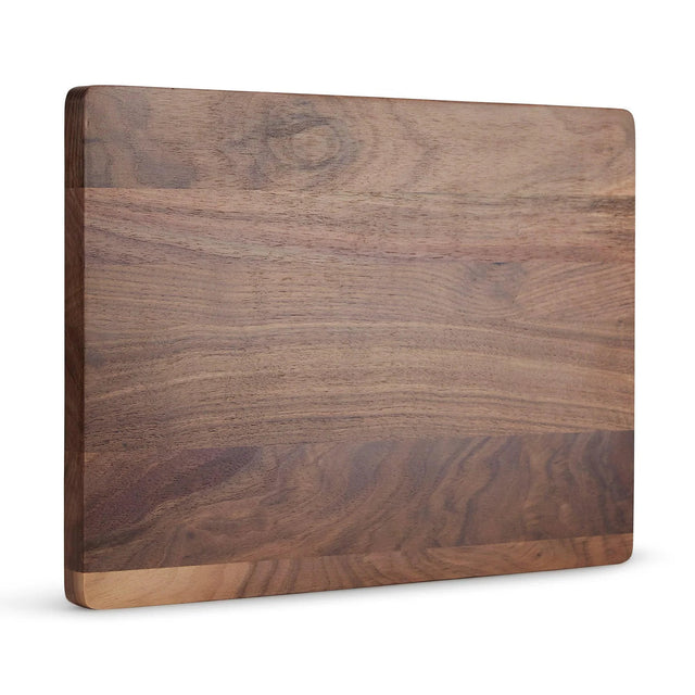 Solid walnut cutting board shown upright against white.