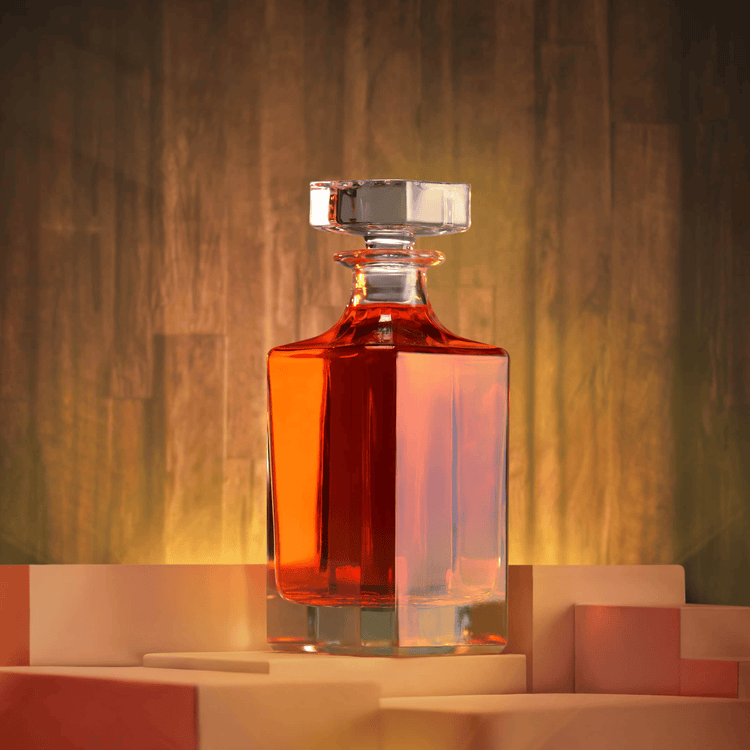 Clear square whiskey decanter filled with amber liquor on a warm backdrop.