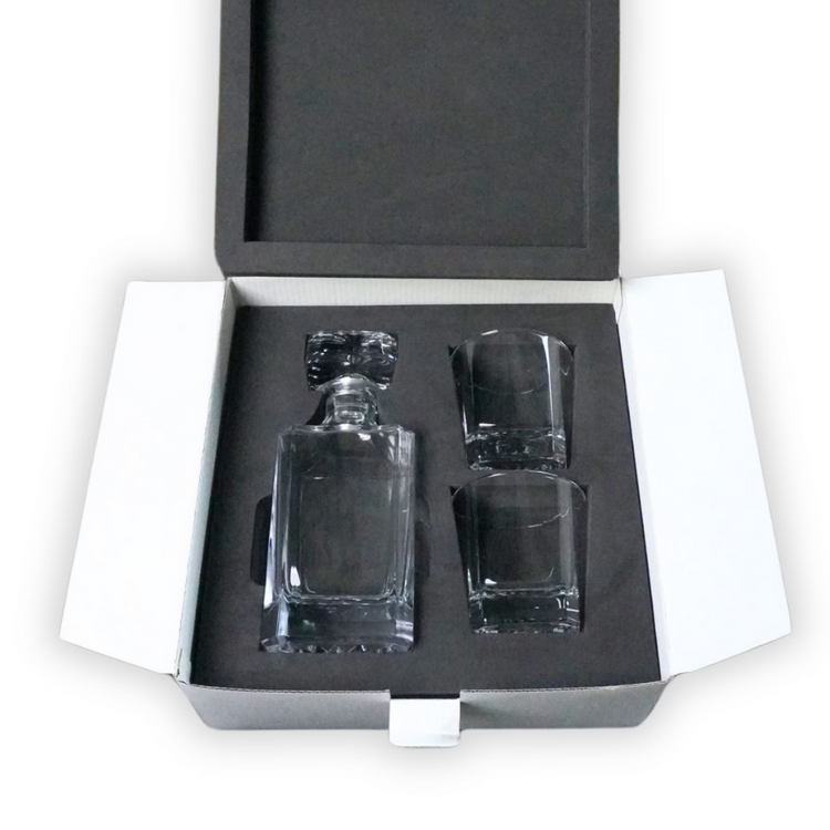 Clear decanter and two rocks glasses nested in a white box with fitted foam.