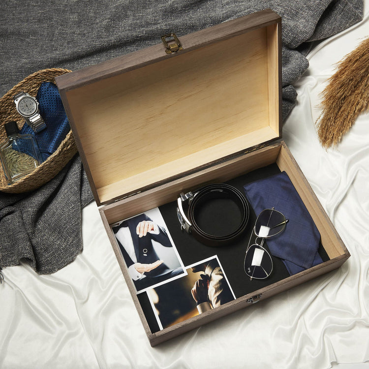 Open black memory box holding watches, photos, and keepsakes.