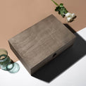 Closed walnut memory box styled on a tabletop with small decor.